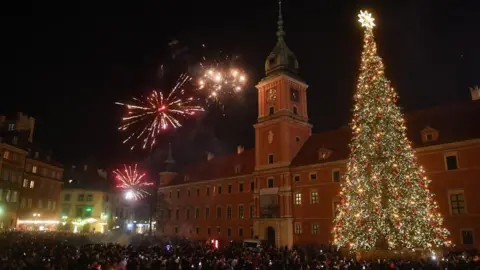 EPA-EFE/REX/Shutterstock Residents of the capital and tourists celebrate the arrival of the New Year at Zamkowy Square in Warsaw, Poland