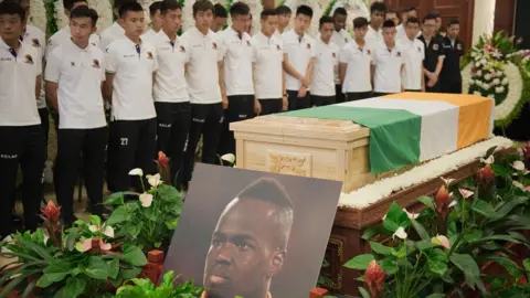Getty Images Beijing Enterprises club football players look at the coffin of Cheick Tiote during a memorial service in Beijing on June 13, 2017. Tiote, who was a member of the Ivory Coast squad that ended a 23-year drought to win the 2015 Africa Cup of Nations, died on June 5, 2017 after "suddenly fainting" during a training session with his second tier Chinese club Beijing Enterprises.