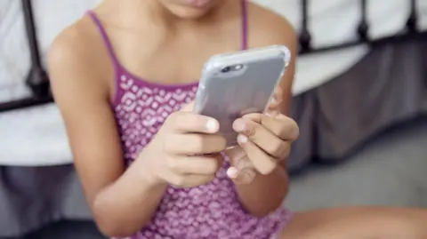 Midsection of girl using smart phone at home