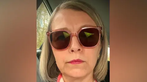 Supplied A selfie of a woman wearing sunglasses. She is sitting in a car.