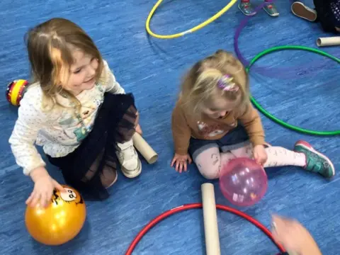 Two girls with balls, tubes and hoops