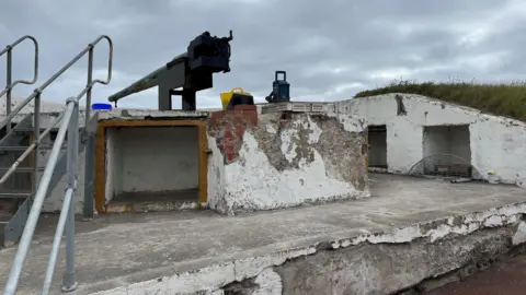 A concrete gunning placement. The white concrete is cracked and decaying.