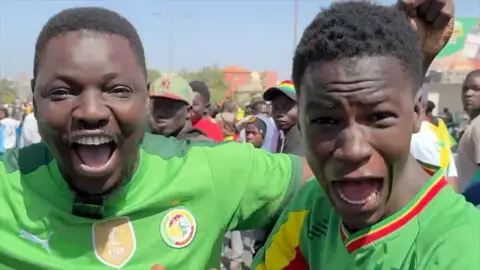 Senegalese fans earing jerseys shouting with joy