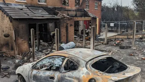 Hughes family Wrecked house and car after wildfire spread to buildings