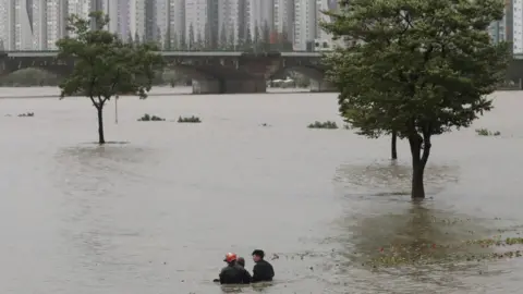 Yonjap/Reuters Firefighters rescue a man from flooded Taehwa river in Ulsan, South Korea, September 6, 2022.