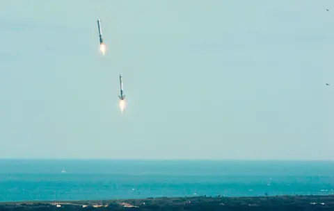 Getty Images Falcon Heavy's booster rockets descend to land at Florida's Space Coast