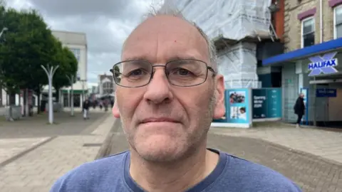 Andrew Turner/BBC Sean Williams standing in Great Yarmouth Market Place