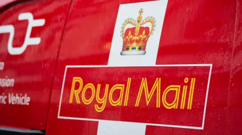 A Royal Mail van's yellow logo on a yellow background