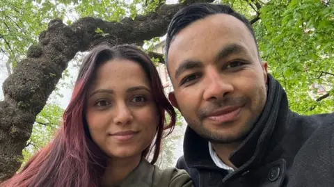 Pramod Poudel A selfie of a man and a woman sitting beneath a tree.