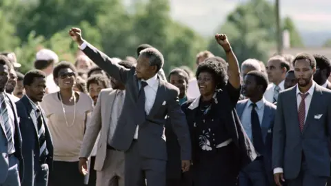 Getty Nelson Mandela walks with Winnie Mandela and dozens of others