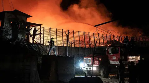 AFP via Getty Images Firefighters douse water on a drug treatment centre that is on fire in Kabul, Afghanistan during the night
