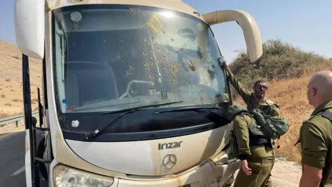 Reuters Israeli soldiers check damage in a bus, at the scene of a shooting attack in the Jordan Valley, in the West Bank (04/09/22)