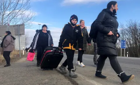 BBC Refugees walk on foot near the Hungarian-Ukrainian border