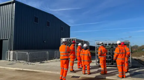 Affinity Water Grey building with workmen outside in orange gear