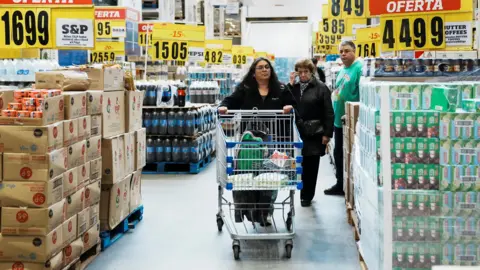 Reuters-Frau schiebt Supermarkteinkaufswagen durch einen Großhändler in Buenos Aires, 10. Mai 2024