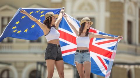 Two young women with flags - one EU flag and one Union Jack