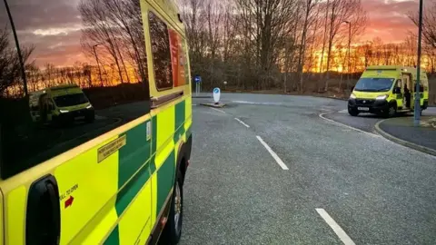 A general view picture of two ambulances on an otherwise empty road.