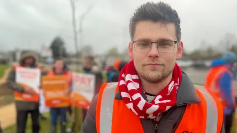 A doctor in a hi-vis vest on a picket line in Swindon