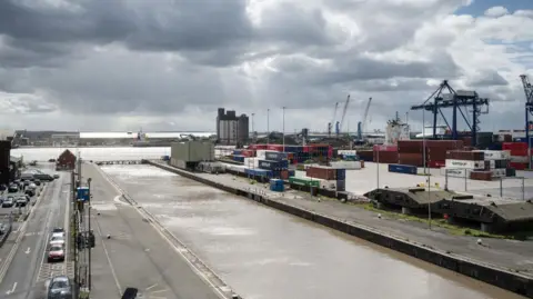 A view from the control tower at the Port of Immingham. It is a grey cloudy day and containers and cranes can be seen beyond the dock side.