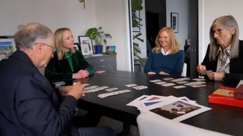 Maxine Collins/BBC (from left to right) The side file of Bill Gates, which fixes cards, Katie Razzall smiles, with Bill's Sisters Libby and Kristi, who plays paper 