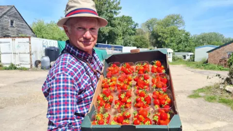 Brian Goodall holding a box full of strawberry punnets