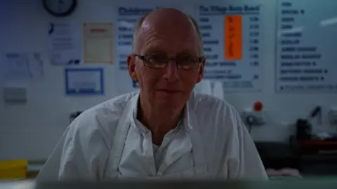 Richard Bolland behind the counter in his fish and chip shop