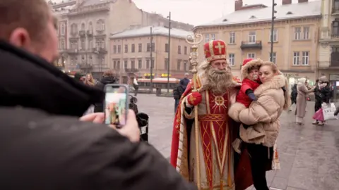 A woman and a child were photographed next to a Ukrainian Santa-like figure