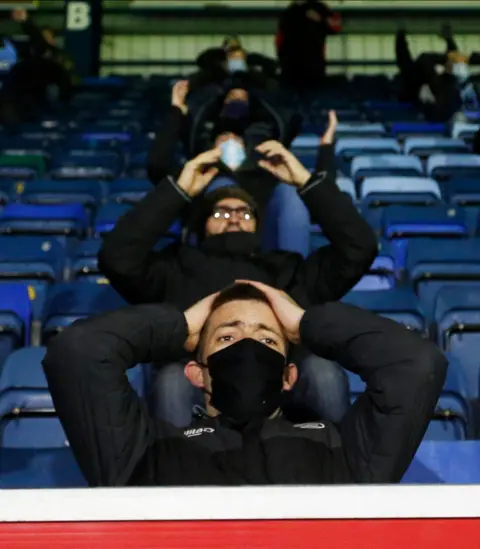 Reuters Wycombe Wanderers fans react during the match against Stoke City at Adams Park, Wycombe