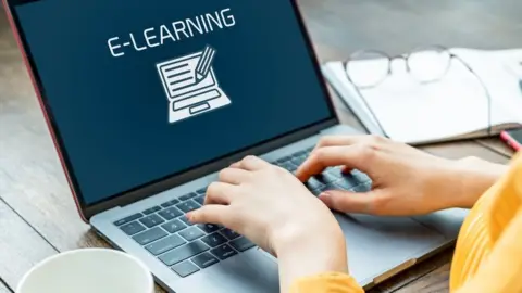 Getty Images Woman on a laptop with e-learning icon