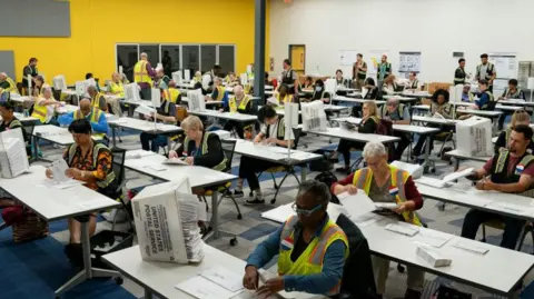 Getty Images North Carolina election officials prepare absentee ballots for the 5 November election