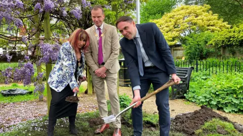 BBC Tanya Morgan, Simon White and Simon Tagg (right) burying the time capsule