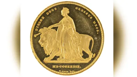 Rogers Jones and Co The coin face one showing the queen and the lion side. You can see her cape and the globe she is holding to her hip and the crown on her head. 