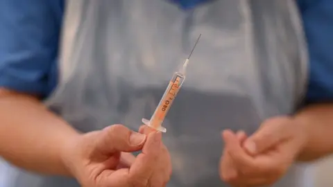 OLI SCARFF/Getty Images Vaccine