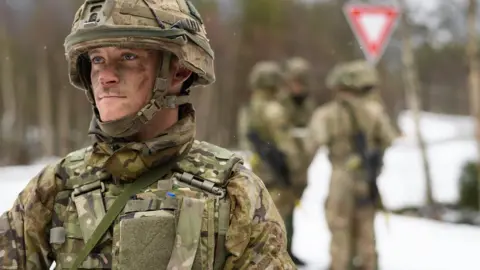 Getty Images A member of the British Army Royal Irish Regiment B Company stands guard as obstruction tactics are discussed