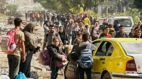 Getty Images Families fleeing Israeli army operations in Jabalia take the main Salah al-Din road towards Gaza City on 23 October. 