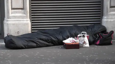 EPA A person lies on the street in a sleeping bag