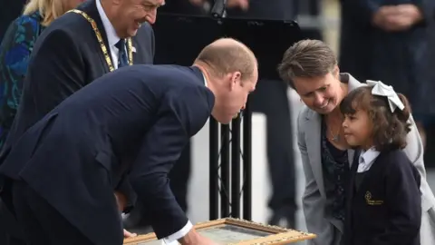 PA The Duke of Cambridge receives a gift from a young girl