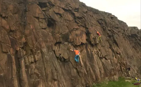 Danny Carden Stephen Venables wearing green trousers climbing Salisbury Crags