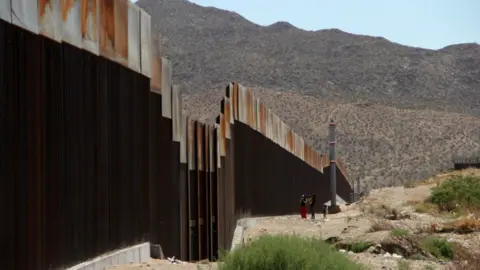 AFP A Mexican family stands next to the border wall between Mexico and the United States, in Ciudad Juarez, Mexico on May 23, 2017