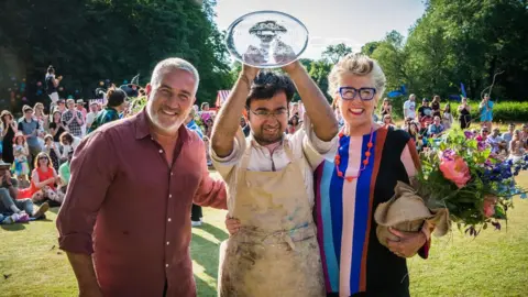 PA Rahul Mandal (centre) is crowned champion by judges Paul Hollywood (left) and Prue Leith (right)