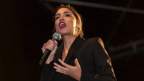 Getty Images Alexandria Ocasio-Cortez with a microphone