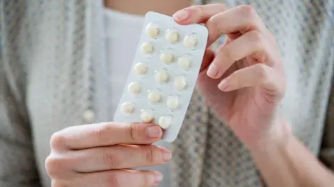 Science Photo Library Woman taking an hormone replacement therapy pills (stock image)