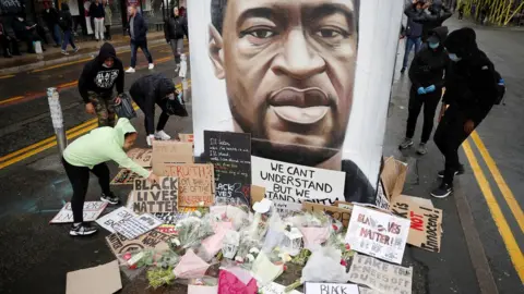 Reuters People left tributes at a mural of George Floyd in Manchester