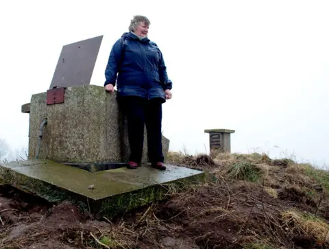 Lee Karen Stow Rosemary 'Christine' Wright stands next to the entrance of a bunker monitoring post on the East Yorkshire Coast