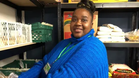 Jon Wright/BBC Volunteer Henriette Uiras working in the pantry, wearing a blue jumper