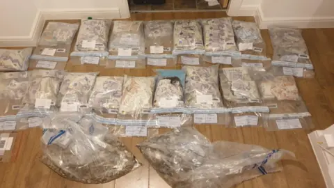 Merseyside Police Bags of banknotes laid out on the floor, in plastic bags, in a property linked to Dunne