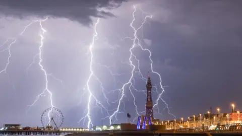 Blackpool tower surrounded by strikes of lighting at night.