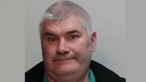 police scotland A mugshot of a man with grey hair wearing a green polo shirt and black jacket