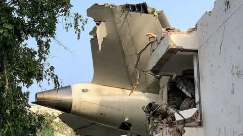 AFP via Getty Images The back of Air India flight 171 is pictured at the site after it crashed in a residential area near the airport in Ahmedabad on June 12, 2025. A London-bound passenger plane crashed in the Indian city of Ahmedabad on 12 June and all 242 people on board were believed killed, with the jet smashing into buildings housing doctors and their families.