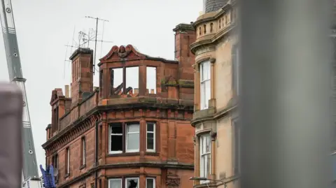 A tenement block in Perth which has been badly damaged by fire. the roof and upper windows have collapsed and several other windows are smashed.